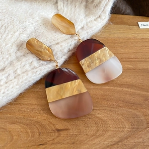 Detailed view of oval acetate drop earrings with multi-color geometric resin segments