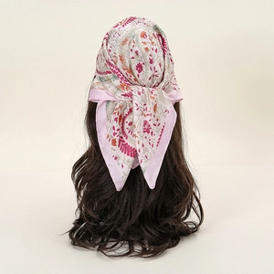 Detailed back view of pink paisley floral satin square scarf tied in long curly hair