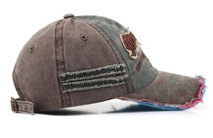 Detail of distressed baseball cap featuring vintage patchwork and metal adjustable buckle