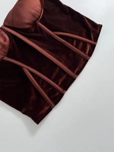 Detailed close-up of dark brown velvet corset top with satin cups and boning structure