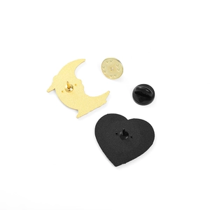 Detailed back view of enamel pins showing gold butterfly clutch and black rubber backing
