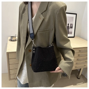 Fashion black rhinestone bucket bag with geometric wide strap shown in stylish interior