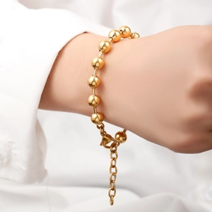 Detail of 18K gold-plated stainless steel bead bracelet worn on wrist with adjustable clasp