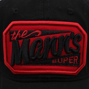 Close-up of the red embroidered shield patch with Mann's SUPER text on a black baseball cap