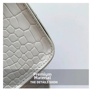Détail de la surface en cuir PU blanc crème avec motif crocodile et coutures précises