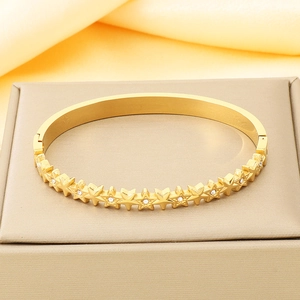 Detail eines sternförmigen 18K vergoldeten Armbands mit funkelnden Kristallen