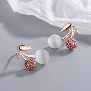 Rose gold cherry stud earrings with white cat eye stones and red cubic zirconia gems