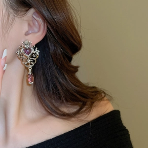 Detail of vintage palace style earring with red heart stone and water drop pendant