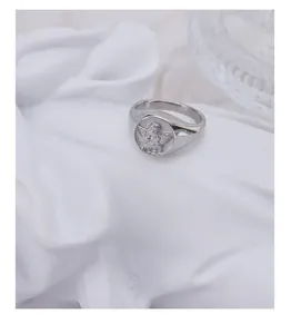 Macro shot of silver angel cherub relief on a round signet ring with vintage finish