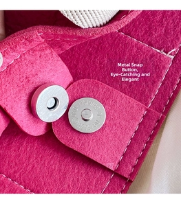 Macro shot of silver magnetic metal clasp on bright fuchsia felt tote bag with white stitching