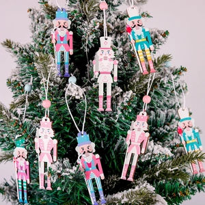 Set of colorful wooden Nutcracker ornaments hanging on a snowy Christmas tree with beads