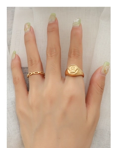 Close-up of vintage 18k gold plated angel relief signet and chain rings on model's fingers