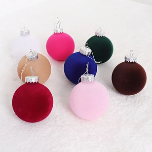 Close-up of velvet flocked Christmas balls in various colors on white fur background