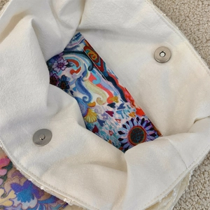 Detail view of canvas bag interior with floral printed pocket and magnetic metal buckles