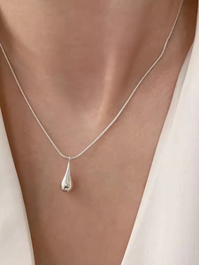 Close-up of minimalist S925 sterling silver water drop pendant on snake bone chain