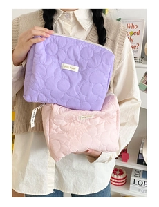 Trousses de maquillage matelassées rose et violet avec texture florale et fermeture