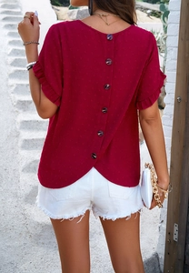 Detail of red short sleeve top featuring ruffle cuffs and elegant back button design