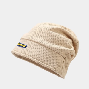 Close-up of beige waffle knit beanie showing texture and Garment decorative label