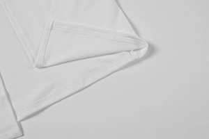 Gros plan des coutures à double aiguille et du tissu dense sur la robe bustier blanche
