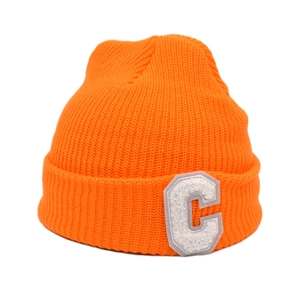 Détail du bonnet en tricot orange avec patch brodé de la lettre C en chenille blanche