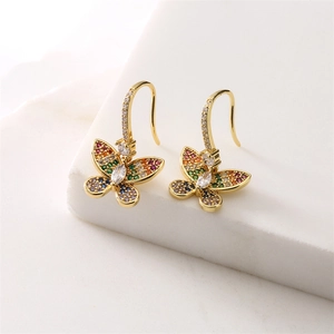 Close-up of golden butterfly earrings with vibrant rainbow cubic zirconia inlay