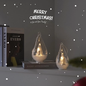 Luminous glass Christmas tree decoration with warm LED light in a cozy winter setting