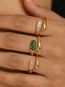 Close-up of gold-plated teardrop rings featuring emerald and pink zircon gemstones