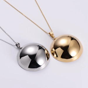 Polished gold and silver hemisphere pendant necklaces with fine chains displayed together