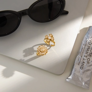 Close-up of gold sunflower and cross star spinning rings with sparkling zircon inlay
