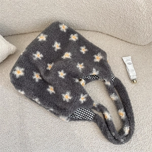 Détail du cabas en peluche à marguerites avec doublure à carreaux et fermoir magnétique