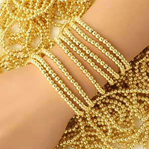 Detail of multi-layer 18K gold-plated beaded elastic bracelets with high-polish finish