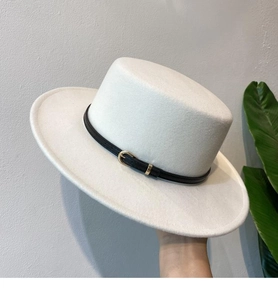 Detail of white wool boater hat featuring a black leather belt with a gold metal buckle
