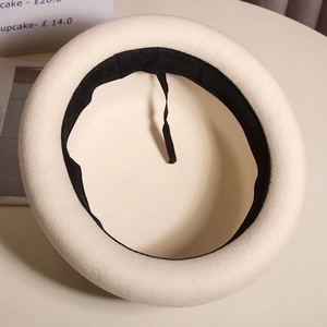 Detail of wool beret interior showing black sweatband and adjustable drawstring