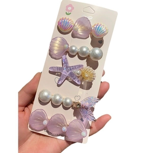 Détails de cinq barrettes marines avec étoiles de mer, coquillages et perles violet et blanc