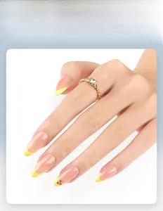 Detailed view of almond nails with yellow French tips and small cherry designs