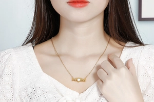 Close-up of MOM letter heart pendant necklace on a model showing golden finish and size