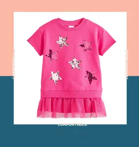 Detail of girls pink dress featuring colorful sequin stars and mesh pleated hemline