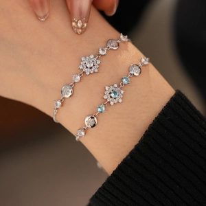 Macro detail of silver flower bracelets with blue topazes and zircons on a wrist