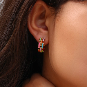 Detail of 18K gold plated chain earrings with colorful pastel enamel on a female model