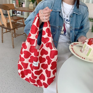 Detail of cream corduroy tote bag with red heart prints and branded woven label