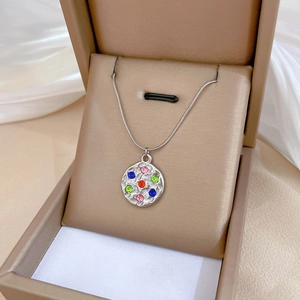 Close-up of silver punk necklace with colorful rhinestones on a round pendant