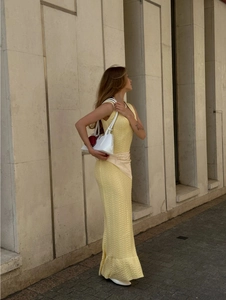 Détail macro d'une robe longue en maille jaune pâle sans manches et texture du tissu