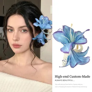 Close-up of a blue lily floral hair claw clip with elegant fabric petals for women