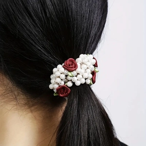 French style red rose and pearl hair tie shown on a ponytail for elegant hairstyling