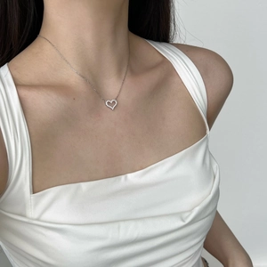Close-up of S925 silver heart necklace with pavé diamonds worn on the collarbone