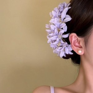 Detailed macro view of an elegant lavender fabric flower hair clip worn by a model