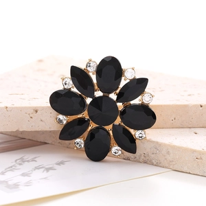 Macro shot of black horse-eye crystal flower accessory with rhinestones on stone base