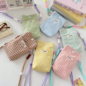 Close-up of colorful checkered canvas phone bags with woven straps in various pastel colors