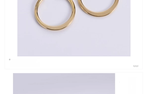 Detail view of smooth polished gold titanium steel hoop earrings with glossy metallic finish