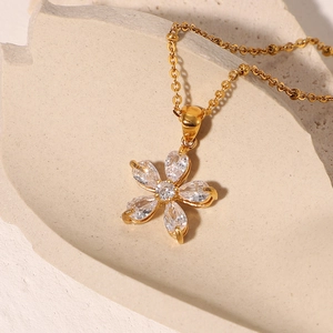 Detailed close-up of 18K gold plated flower pendant necklace with white cubic zirconia
